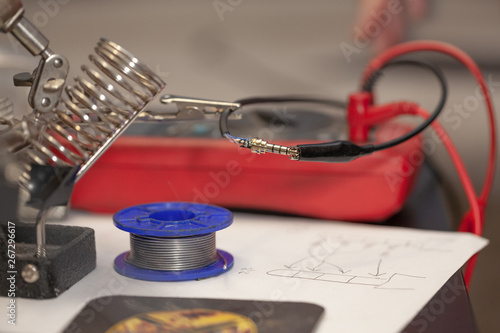 electrician repairing electrical component, on the table with the device and tools, close up, blurry background