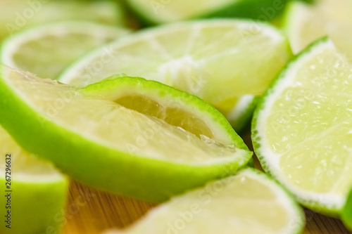 lime slices on wooden table, close up blurry background