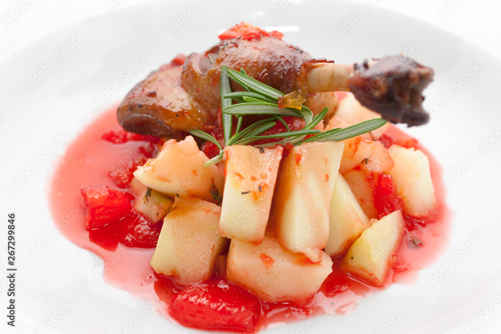 fried duck leg with potatoes and rosemary in red apple sauce confiture on a white background fried duck leg with potatoes and rosemary in red apple sauce confiture on a white background