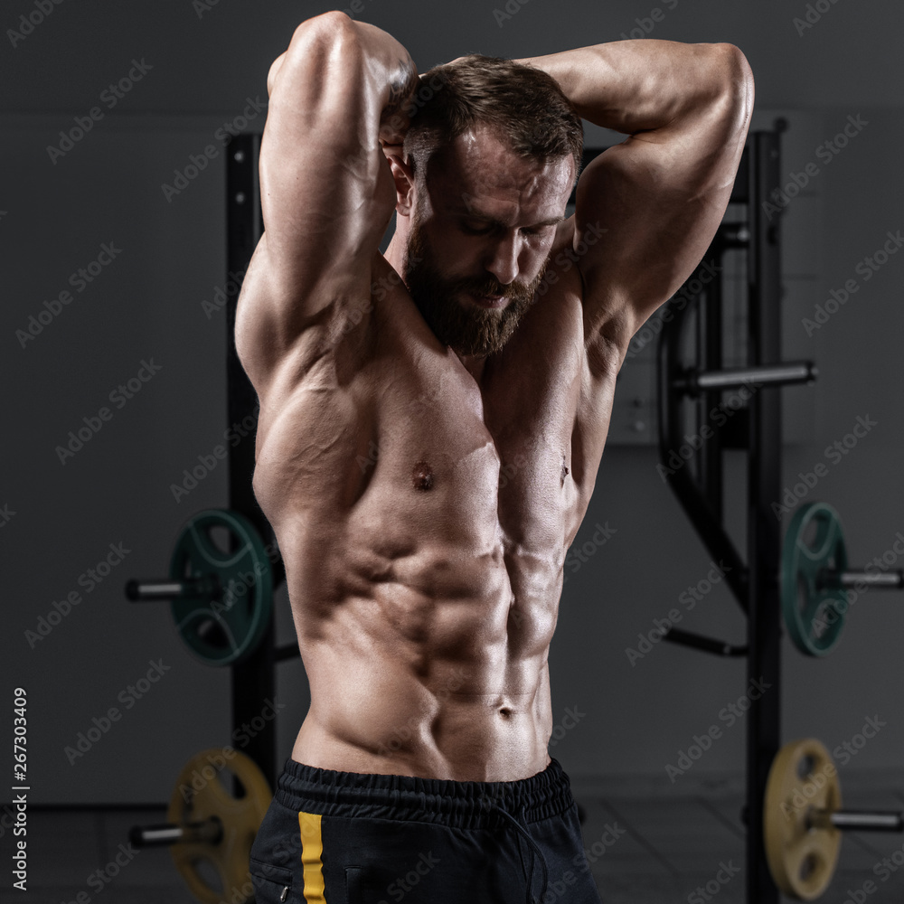 Muscular man in gym showing muscles abs. Strong male naked torso Muscular man in gym showing muscles abs. Strong male naked torso
