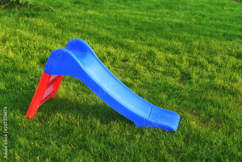 Colorful children's slide on grass in park