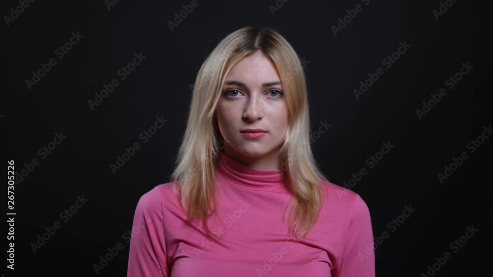 Closeup shoot of young pretty blonde female looking at camera with background isolated on black Closeup shoot of young pretty blonde female looking at camera with background isolated on black