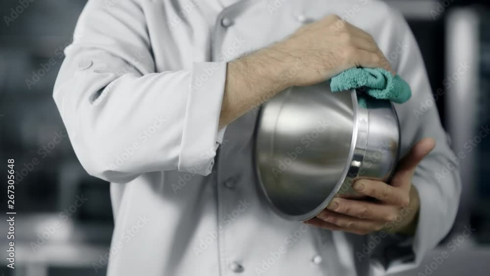 Chef man preparing to cook. Closeup man hands polishing bowl at kitchen. Chef man preparing to cook. Closeup man hands polishing bowl at kitchen.
