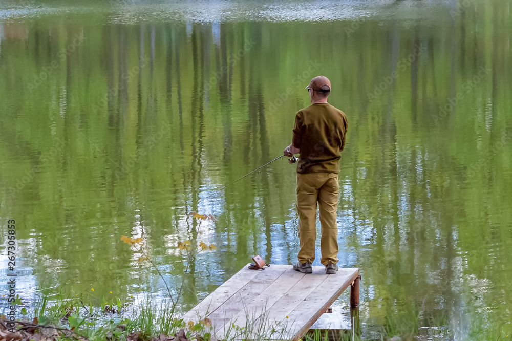 Fisherman with a fishing rod on the pond