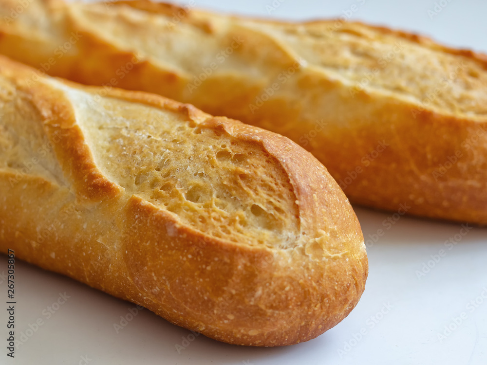 Crispy Golden crust of French baguettes on a light background. Two mouth-watering French baguette Crispy Golden crust of French baguettes on a light background. Two mouth-watering French baguette