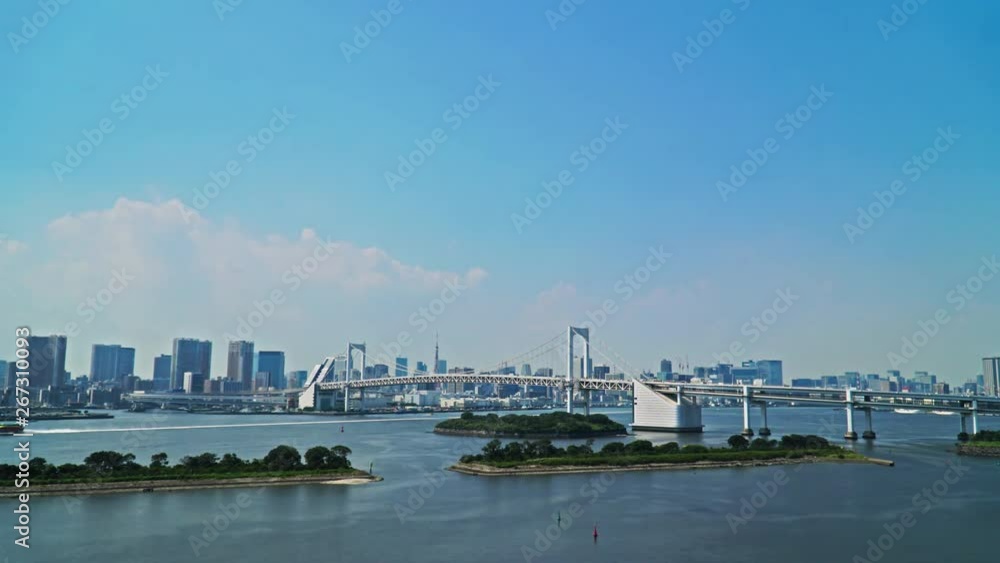 Tokyo time lapse of Rainbow Bridge and bay, cityscape skyline background, blue sky white clouds background. Tokyo time lapse of Rainbow Bridge and bay, cityscape skyline background, blue sky white clouds background.