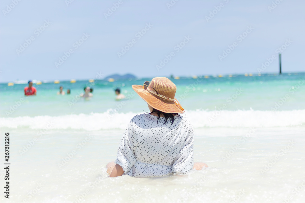 Young women traveling relax on the beach on summer, Concept beach on summer,Rear view of a girl sitting the beach