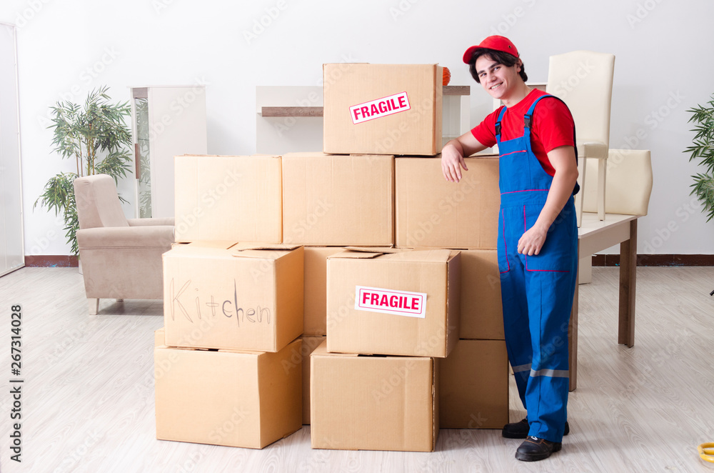 Young male contractor with boxes working indoors Young male contractor with boxes working indoors