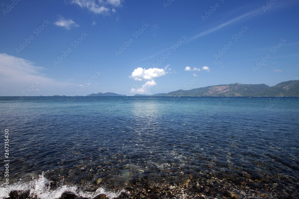 Idyllic crystal seawater in front of luxury hotel, attractive clear sea, nature coastline backgrounds during holidays, wave from clear blue green sea and fine sand