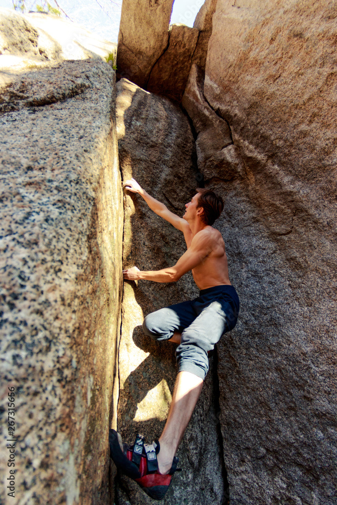 rock climber climbs a boulder over a rock without insurance rock climber climbs a boulder over a rock without insurance