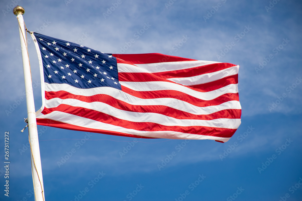 american flag waving in the wind against blue sky american flag waving in the wind against blue sky