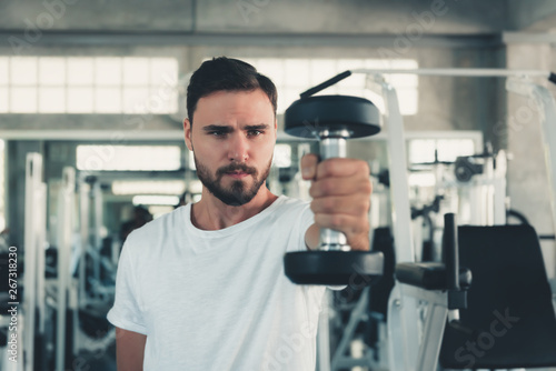 Handsome Sporty Man is Exercising With Dumbbell in Fitness Club.,Portrait of Strong Man Doing Working Out Muscles-Busbuilding Weight Dumbbells in Gym Club., Healthy and Sport Fitness Lifestyle Concept