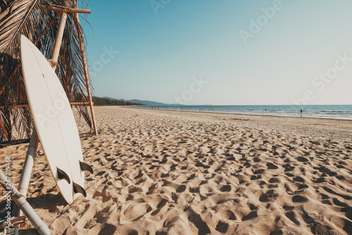 Photography Surfboard on sand tropical beach with seascape calm sea and sky background