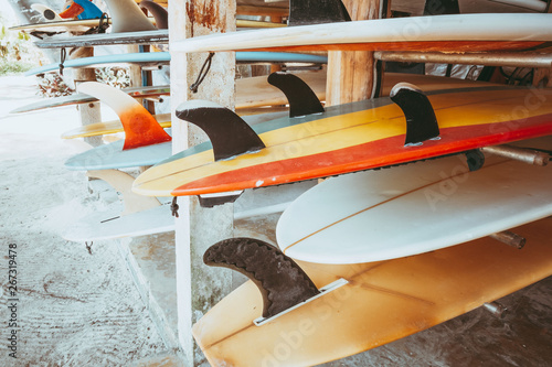 Canvas Print Set of different colorful surf boards in a stack available for rent on the beach
