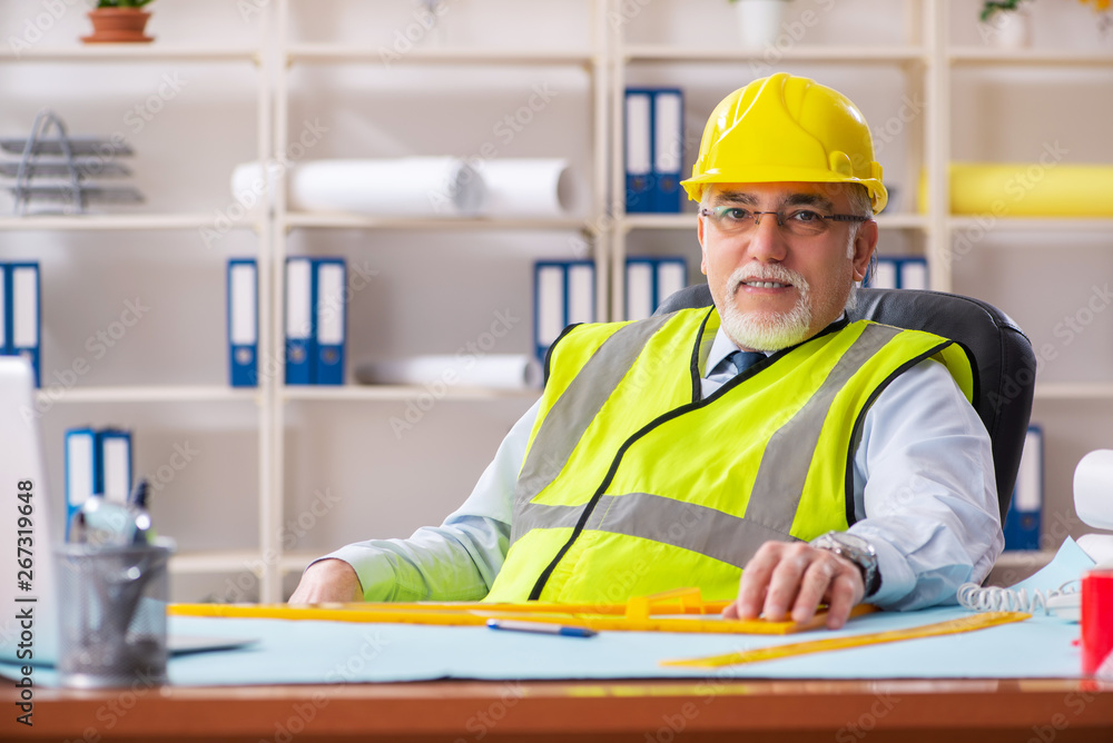 Aged construction engineer working in the office Aged construction engineer working in the office