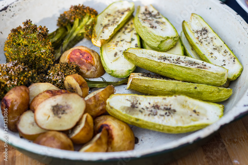 Baked, roasted vegetables on frying pan skillet. Potato, zucchini, potato with spices