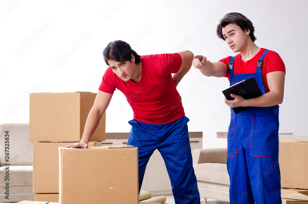 Two young contractor employees moving personal belongings Two young contractor employees moving personal belongings