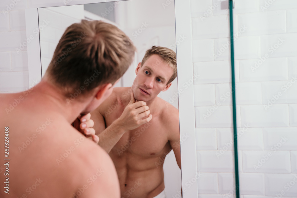 Handsome athletic men shirtless at front reflection the mirror in the bathroom