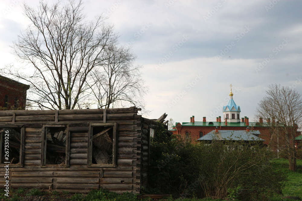 Old and new, wooden ruin and monastery on the background, Russia Old and new, wooden ruin and monastery on the background, Russia