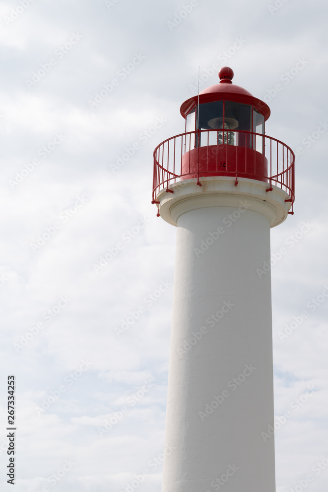 red and white lighthouse for boat in cloud sky vertical