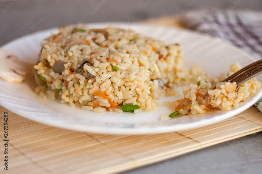 White plate with spicy pilaf with mushrooms White plate with spicy pilaf with mushrooms