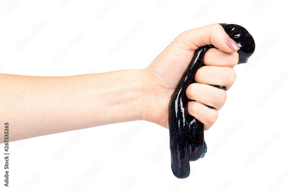 Hand with black slime toy for kids, glitters and goo. Hand with black slime toy for kids, glitters and goo.