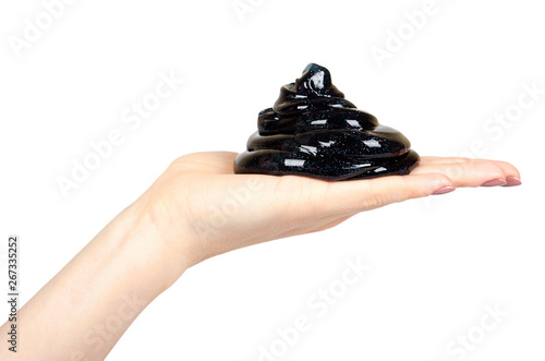 Hand with black slime toy for kids, glitters and goo.