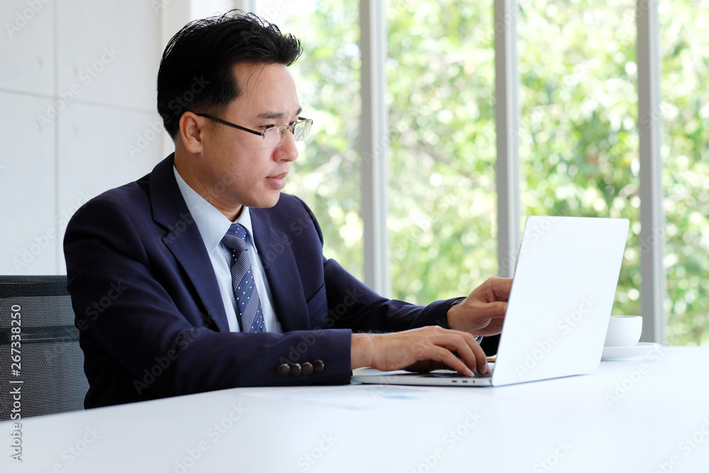 Asian businessman working with laptop computer at office, business concept Asian businessman working with laptop computer at office, business concept