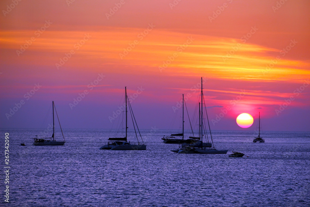 Sunset at sea with silhouette yachts and twilight sky