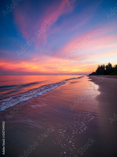 Sunrise with dramatic color sky over sea and beach.