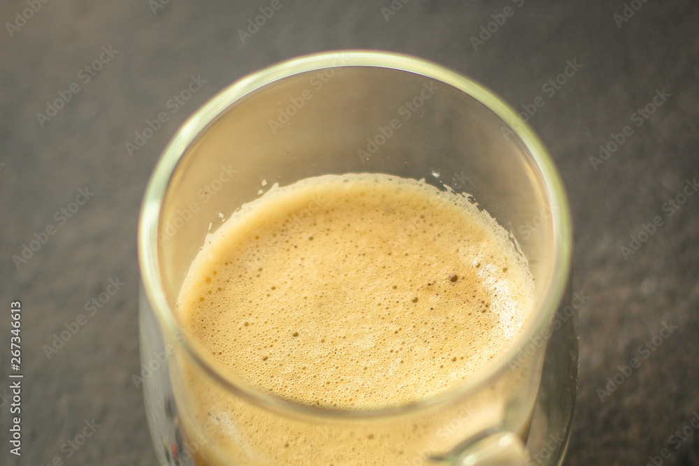 coffee with milk (cappuccino or latte) flavored drink in a transparent cup. food background. top coffee with milk (cappuccino or latte) flavored drink in a transparent cup. food background. top