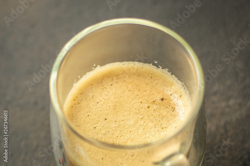 coffee with milk (cappuccino or latte) flavored drink in a transparent cup. food background. top