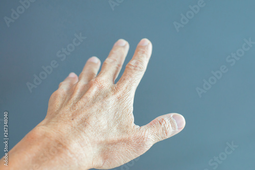 The gesture of the hand extended to the elderly on a gray backgr