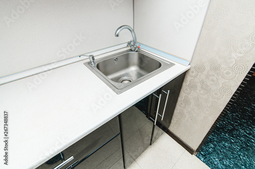 The photo of a sink in a The photo of a sink in a kitchen