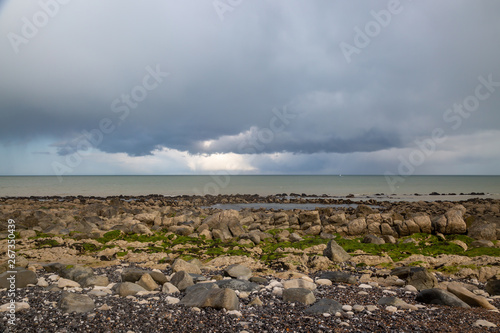 Looking out to sea over a rocky beach at low tide, near Eastbourne in Sussex