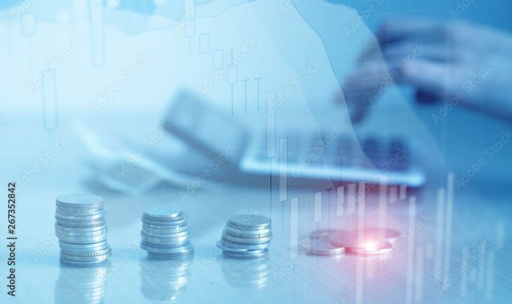 Double exposure of financial graph chart and rows of coins with calculator for finance and business concept Double exposure of financial graph chart and rows of coins with calculator for finance and business concept