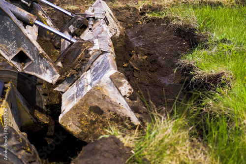 Fototapeta Naklejka Na Ścianę i Meble -  excavator bucket digging pit during earth works