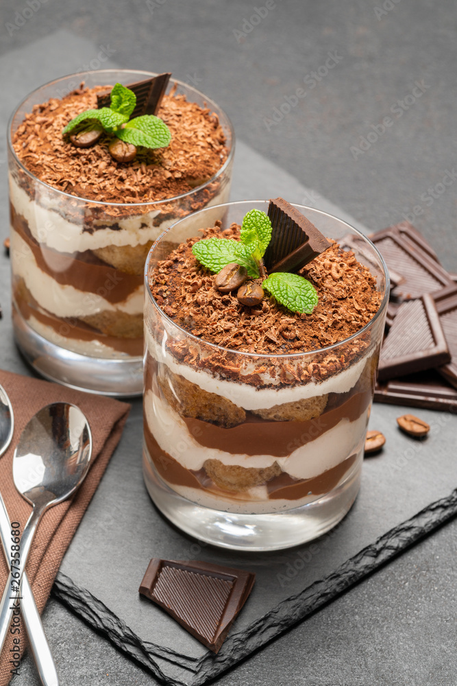 Classic tiramisu dessert in a glass on dark concrete background Classic tiramisu dessert in a glass on dark concrete background