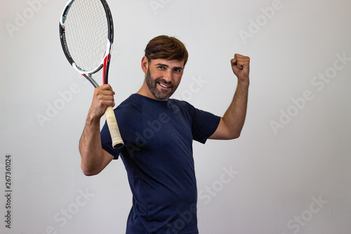 Portrait of handsome young man playing tennis holding a racket with brown hair looking with lust, their back facing the camera and looking at the camera. Isolated on white background. © Sergio Barceló