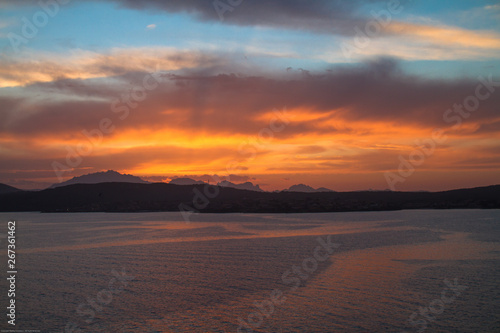 Sunrise on the Sardinian sea coast with intense orange color seen from the sea