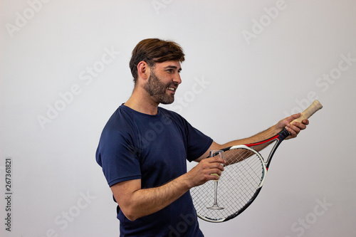 Portrait of handsome young man playing tennis holding a racket with brown hair giving a thumbs up, facing forwards and looking at the side. Isolated on white background.