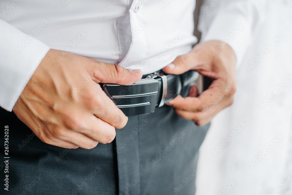 the guy fastens the belt on black trousers the guy fastens the belt on black trousers