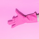 Fashion creative concept with hand in pink rubber glove, showing gesture. Symbol of dog's head. Aesthetic abstract minimalism.
