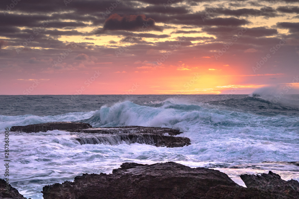 Obraz premium Sunrise with rocks and waves at Cemetery Point, Norfolk Island