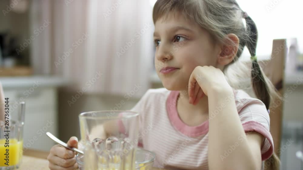 lovly girl having meal with cornflakes and milk and looking around lovly girl having meal with cornflakes and milk and looking around