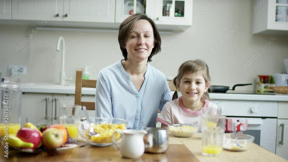mother and daughter sitting at the table together during the lunch mother and daughter sitting at the table together during the lunch