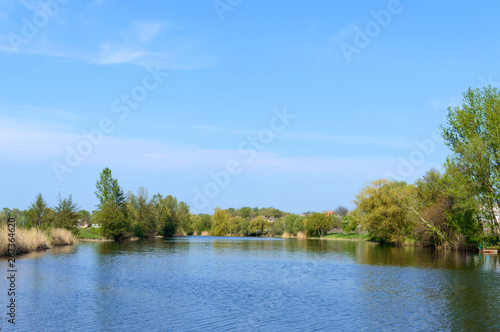 Beautiful view of the river and blue sky. Summer landscape. Place to relax, picnic. Village.