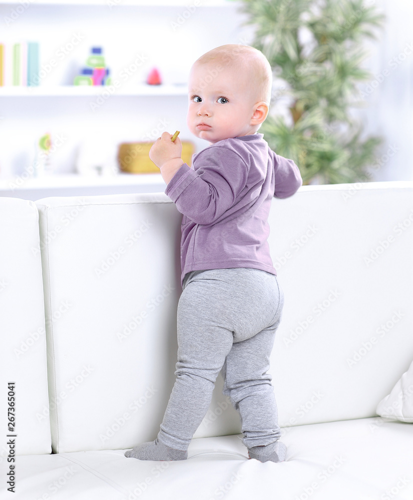 portrait of pretty baby standing on the couch. portrait of pretty baby standing on the couch.