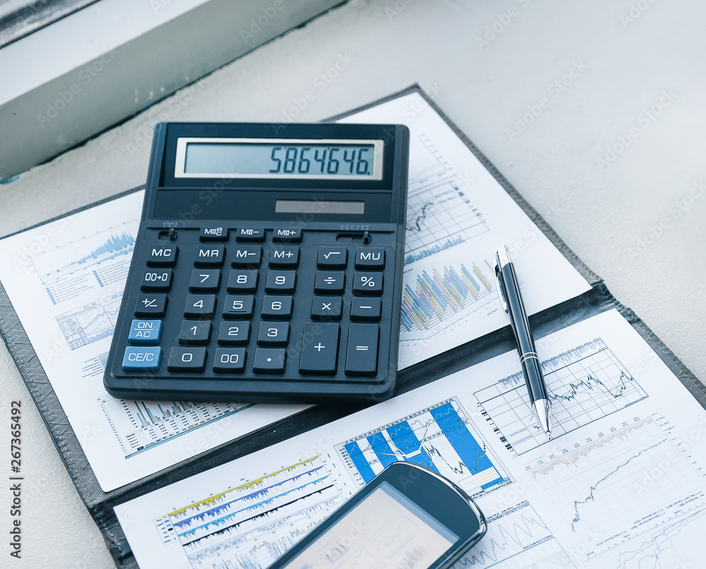 calculator, smartphone and financial documents on the businessm calculator, smartphone and financial documents on the businessm