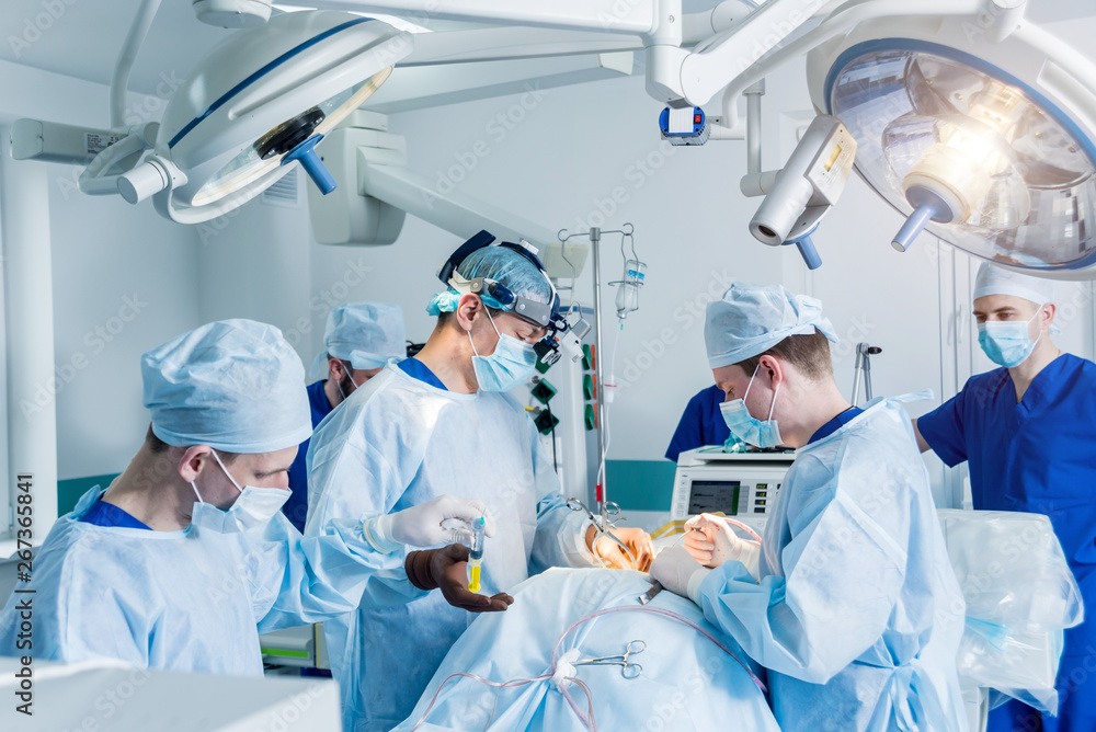 Spinal surgery. Group of surgeons in operating room with surgery equipment. Laminectomy Spinal surgery. Group of surgeons in operating room with surgery equipment. Laminectomy